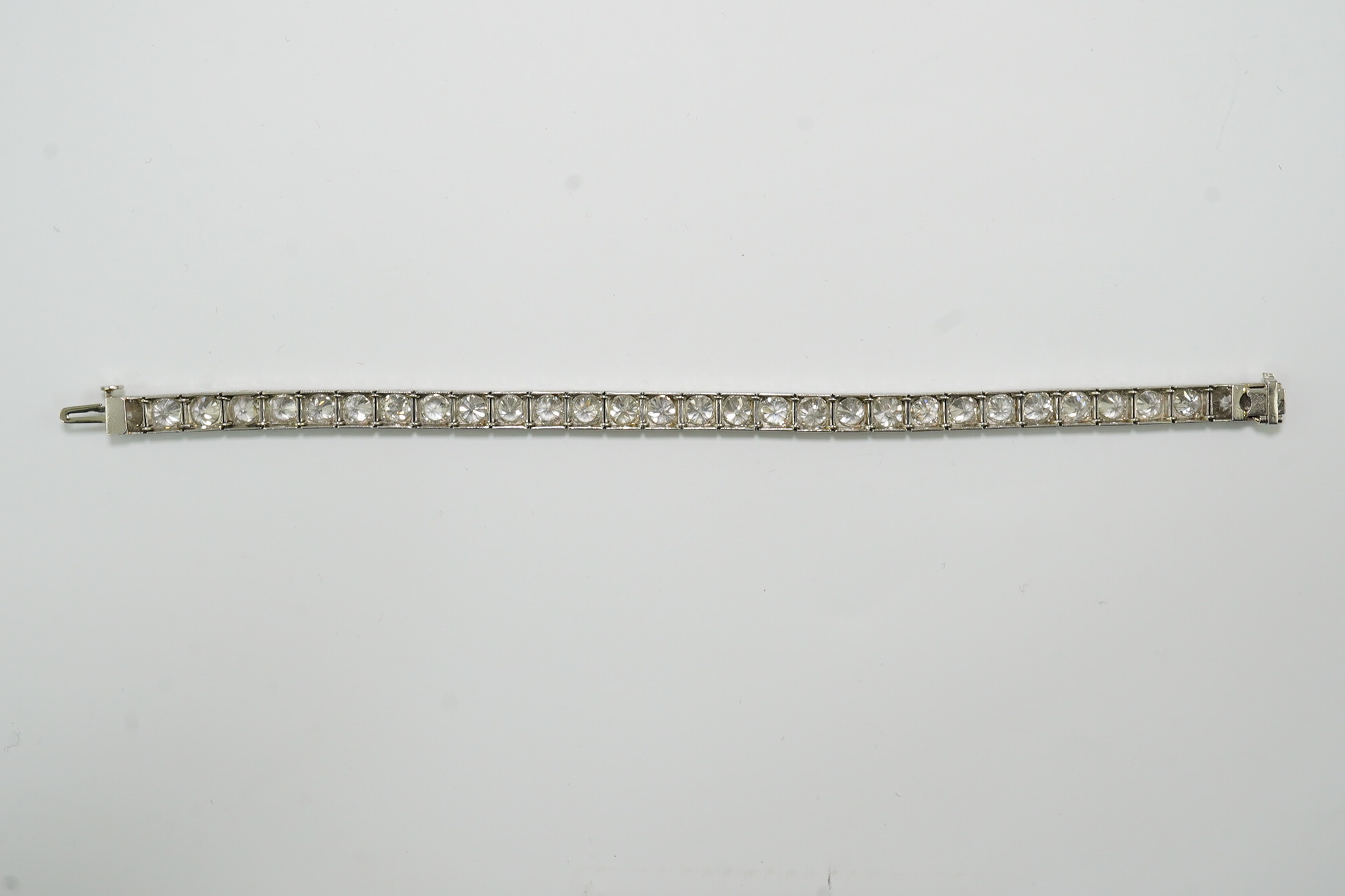 A platinum and thirty one stone round cut diamond set line bracelet